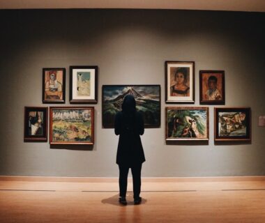 Bezoeker bekijkt schilderijen in een sfeervol verlichte museumzaal